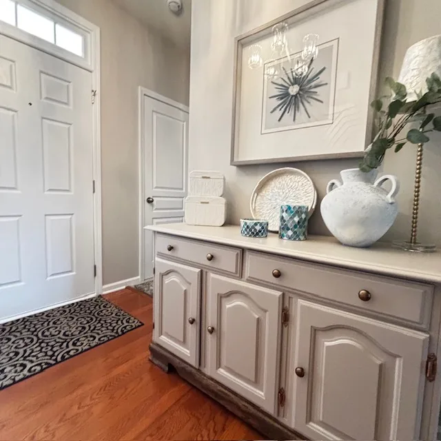 Decorated entryway console with art, ceramics and greenery