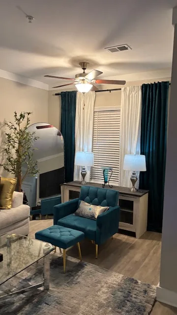 Living room with teal accent chair and layered curtains